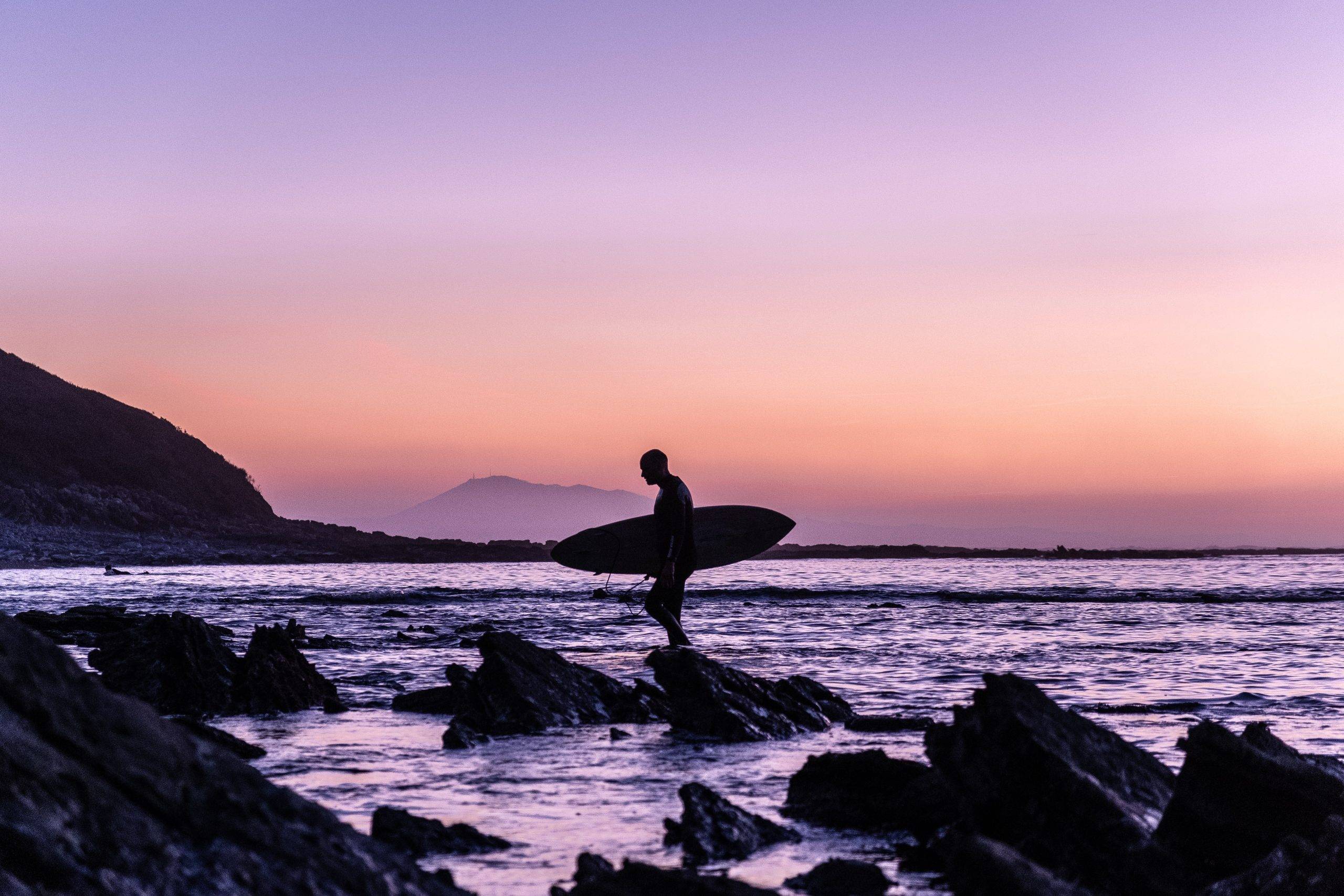 minimalist response to negative external events - surfer at dusk