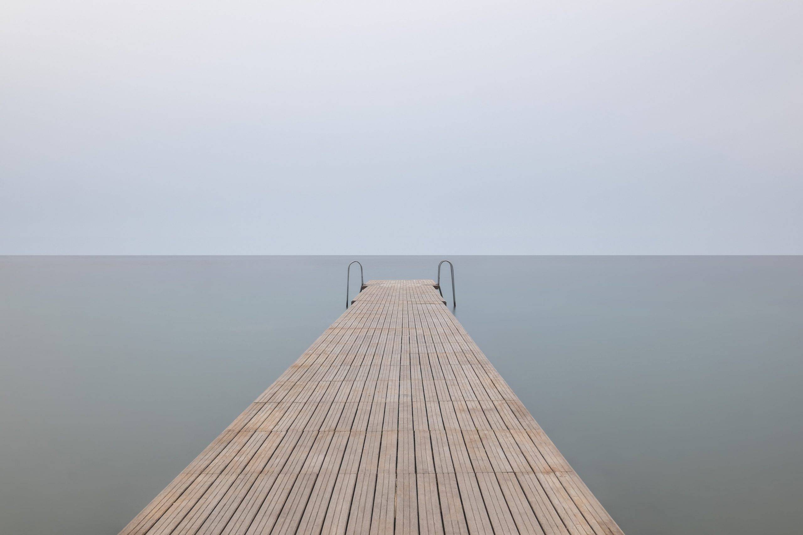 6 Common Struggles For First-Time Minimalists - wooden panel stretching out into the water