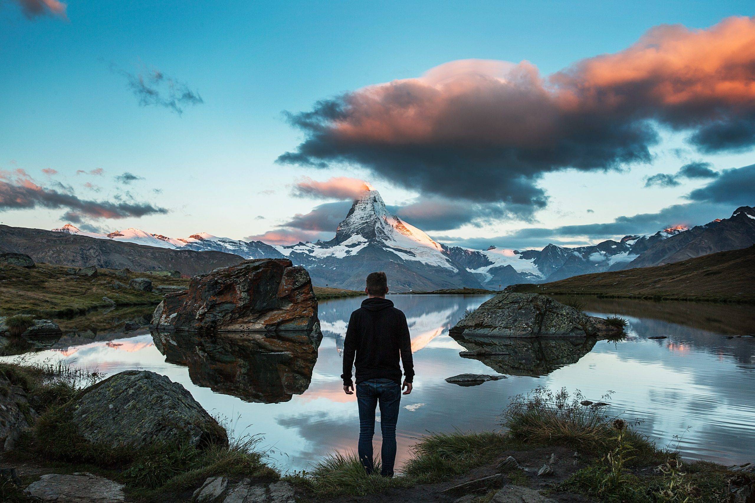 10 Things in Life That Just Aren't Worth Your Time, Effort, or Money - man standing in Swiss mountains in front of lake