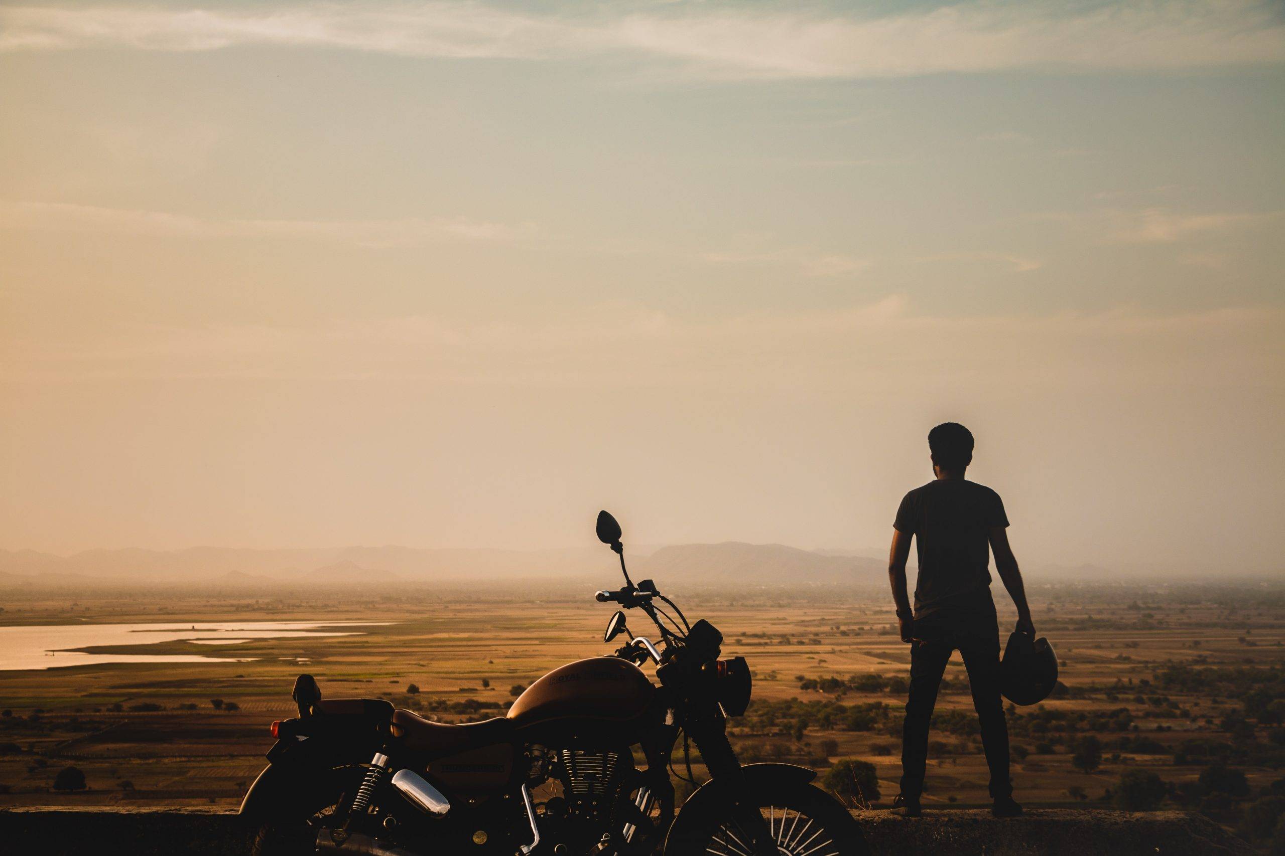 Essential Traits of People With a Strong Character - featured image - man with motorcycle at sunset