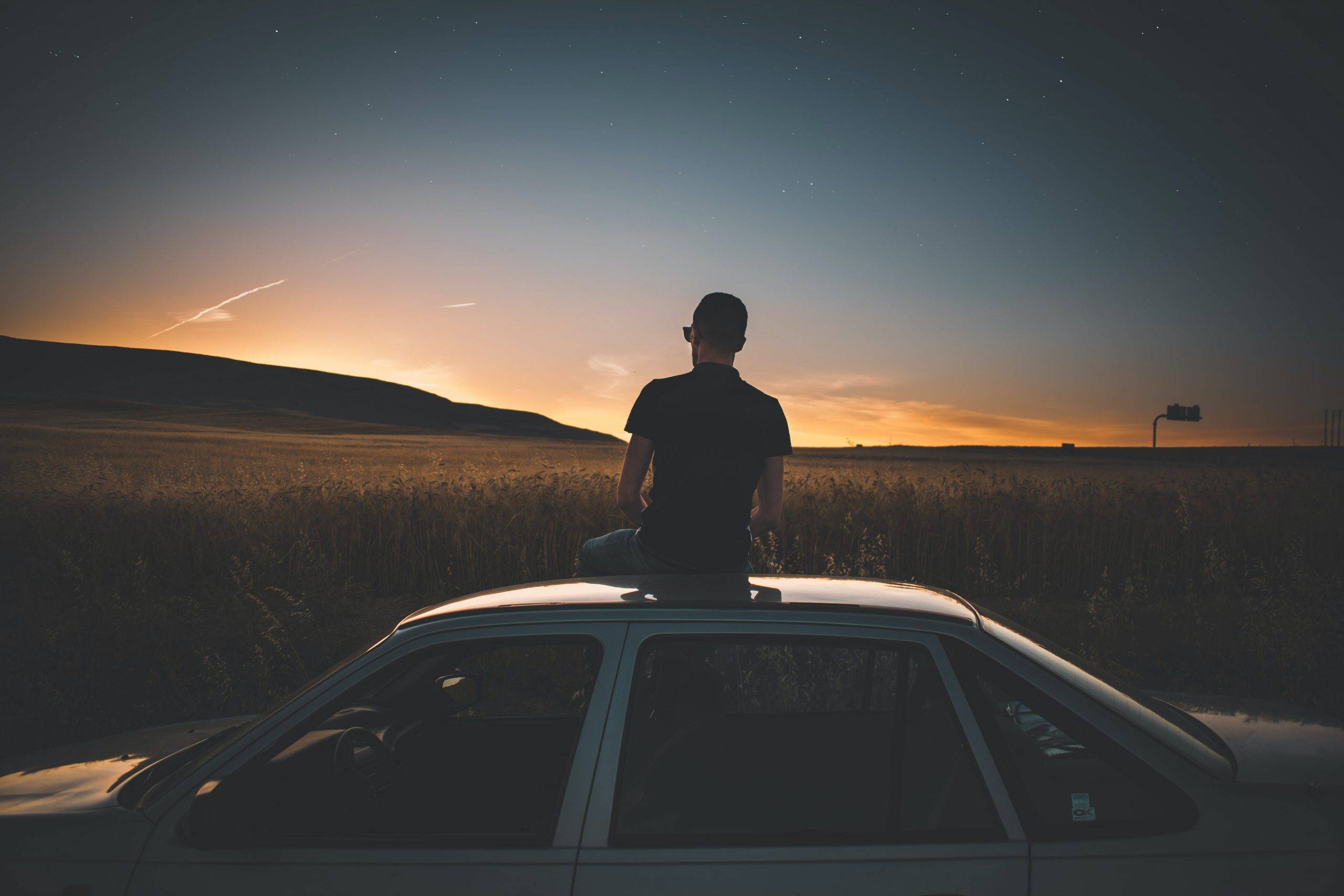 Ways to Increase Your Output by Reducing Your Effort - man sitting on car at sunset