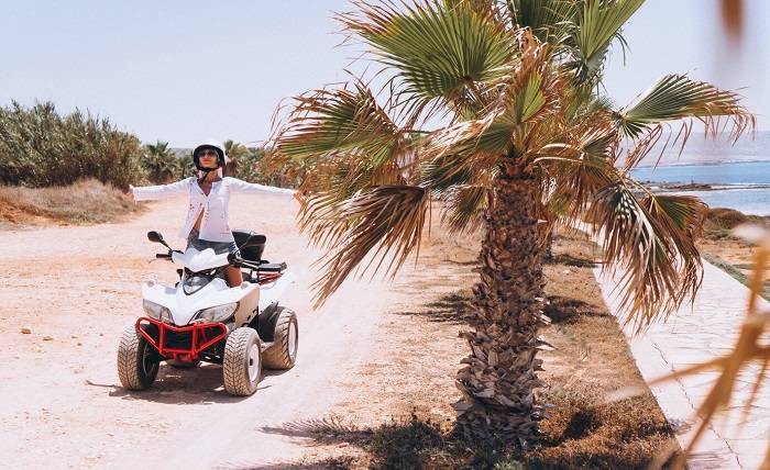 ATV Thrills: Best Quad Biking Spots in the Emirates woman travelling quad by th ocean 1303 10019
