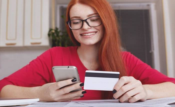 How to Build Credit in Canada Using a Credit Card redhaired pretty female model eyewear holds smart phone credit card 176532 7577